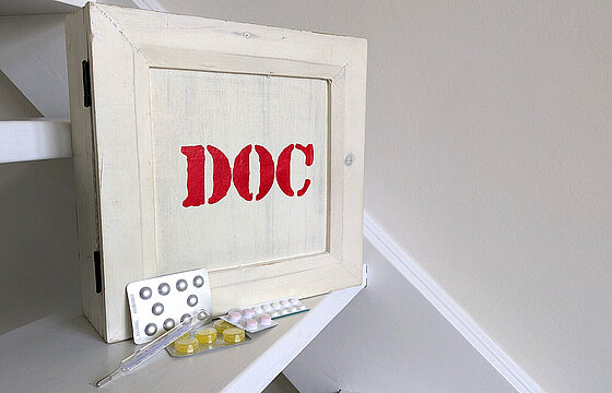Eine Medikamentenbox, davor Tabletten