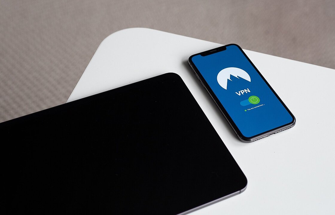 Ein Tablet und ein Smartphone auf einem Tisch - auf dem Smartphone steht "VPN"