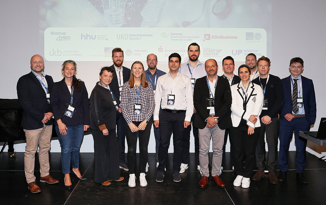 Gruppenfoto aller Teams die gepitcht haben, auf der Bühne des Pitch4MED.