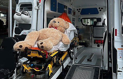 Blick in einen Krankenwagen  - ein großer Teddy liegt auf der Bahre